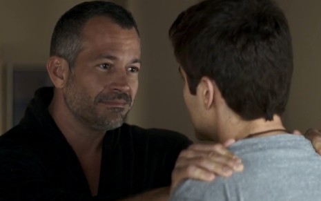 Malvino Salvador com as mãos nos ombros de Guilherme Leicam (de costas) em cena como Agno e Leandro de A Dona do Pedaço