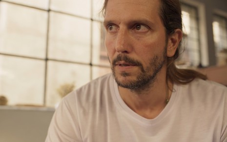 De camiseta branca, Vladimir Brichta tem expressão séria em cena de Amor de Mãe como Davi