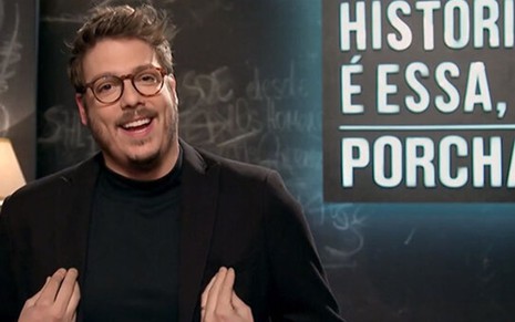 O apresentador Fábio Porchat sorri no cenário do Que História É Essa, Porchat?