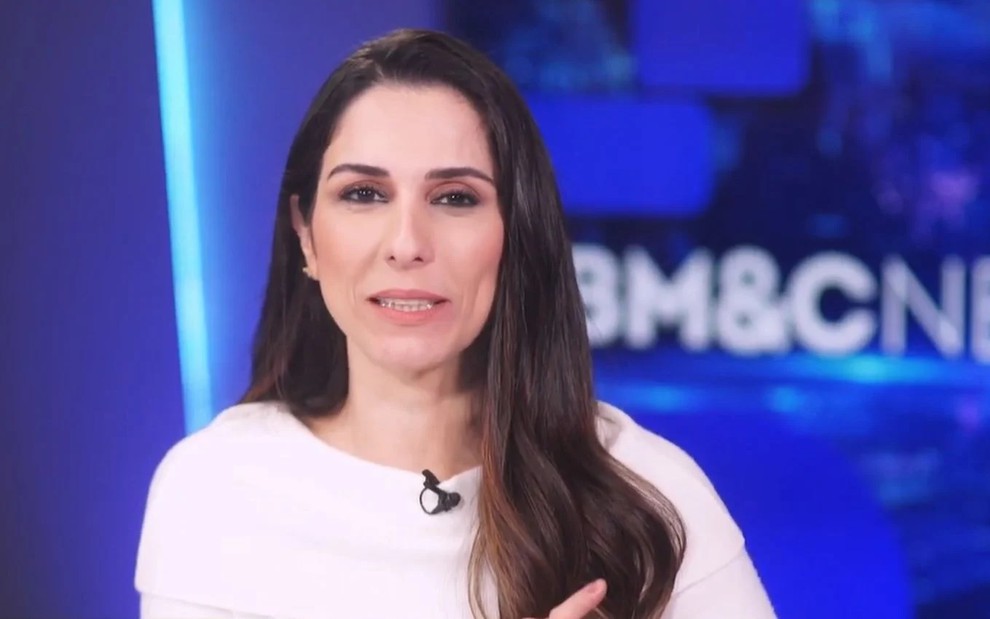 Paula Moraes com uma blusa branca e apresentando um programa na BM&F News