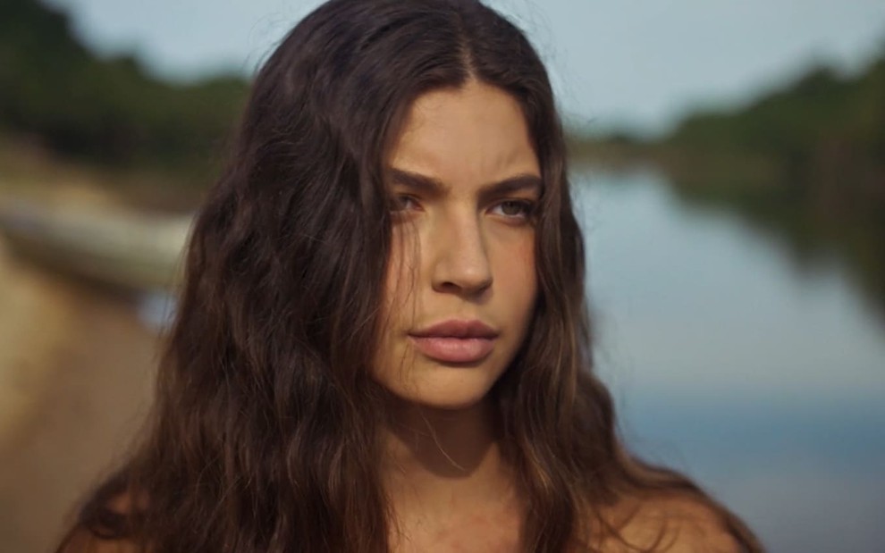 Alanis Guillen, caracterizada como Juma, tem a expressão séria --as sobrancelhas franzidas e a boca, apertada-- em cena de Pantanal