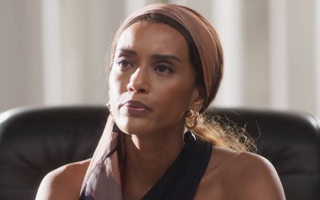Atriz Taís Araujo olha para cima com cara de séria em cena de Cara e Coragem, novela das nove da Globo