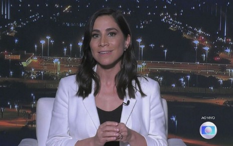 Julia Duailibi no Jornal da Globo; ela está de branco com cenário de Brasília ao funo