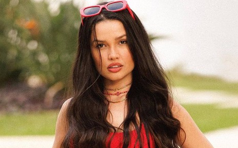 Foto de Juliette vestindo um biquíni vermelho e um óculos vermelho na cabeça