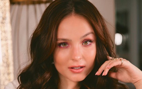 A atriz Larissa Manoela com uma das mãos no cabelo