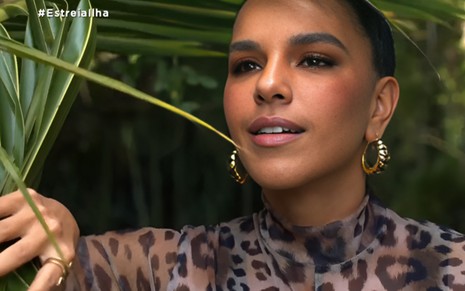 Mariana Rios afasta plantas, na abertura da primeira temporada da Ilha Record