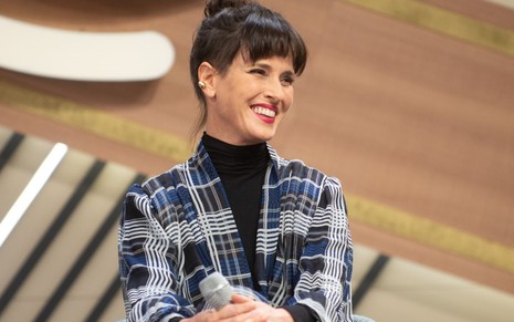 Helena Rizzo sentada no MasterChef Brasil e sorrindo