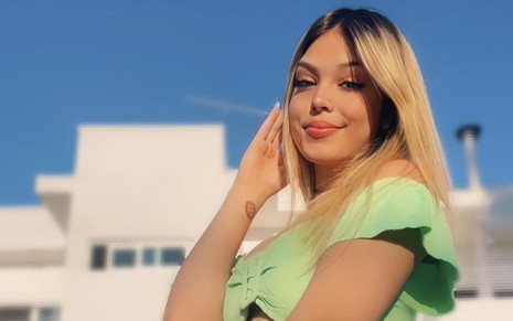 Imagem de Melody de cabelo solto e top verde