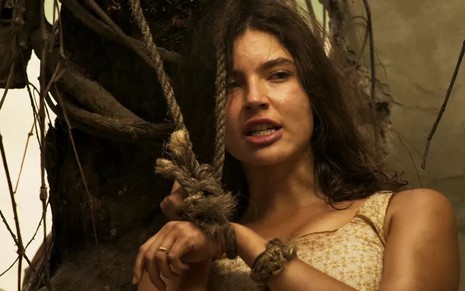 Alanis Guillen tem os cabelos castanhos soltos e o semblante ferino em cena de Pantanal
