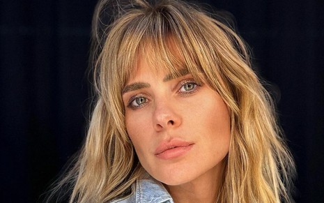 De franja e blusa jeans, Carolina Dieckmann posa para foto