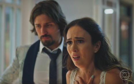 Daniel Rocha está ao lado e Tatá Werneck, que faz uma expressão dramática, em cena da novela Terra e Paixão
