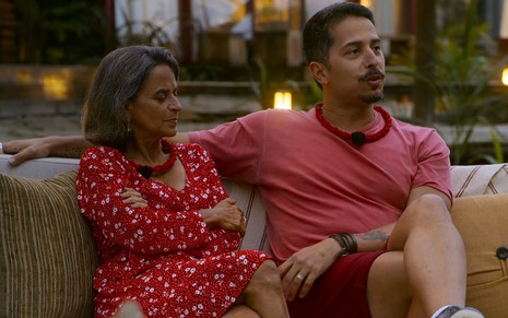 Socorro Sales e Felipe Carvalheira sentados lado a lado em cena do reality Ilhados com a Sogra