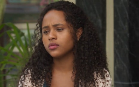 A atriz Duda Santos com expressão triste em cena de Garota do Momento