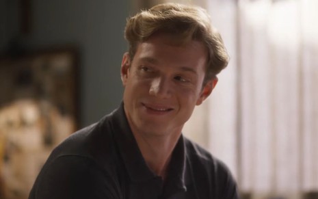 O ator Pedro Novaes com leve sorriso em cena de Garota do Momento