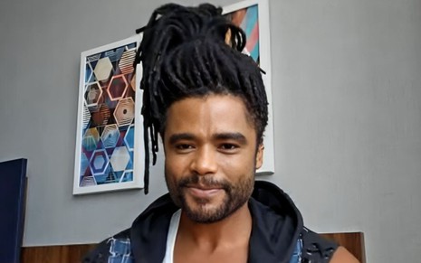 Diogo Almeida em chamada de vídeo no Encontro; ele está com os dreads do cabelo presos em coque