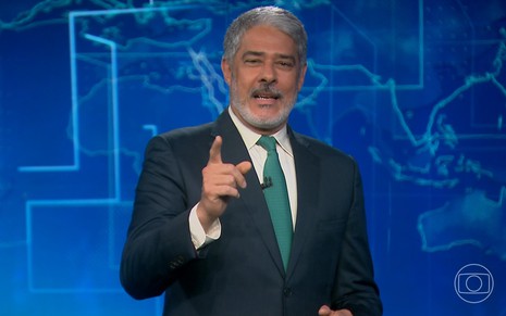 William Bonner tem expressão desconfiada enquanto aponta o dedo indicador na direção da câmera