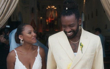 Vestidos como noivos, Jéssica Ellen e Fabrício Boliveira estão sorridentes na saída de uma igreja