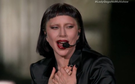 Lady Gaga canta com peruca preta e batom bem vermelho