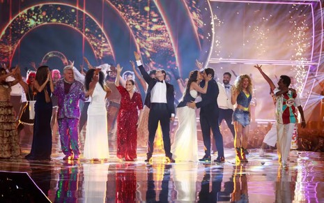 Milton Cunha, Susana Vieira, Eduardo Sterblitch com as mãos ao alto no palco dos 60 anos da Globo; Sabrina Sato e Nicolas Prattes se beijam; Isadora Cruz e Luis Miranda aparecem rindo