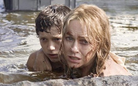 Tom Holland e Naomi Watts abraçados no meio de uma correnteza em cena de O Impossível