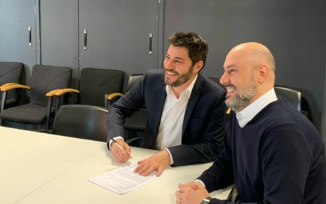 Evaristo Costa, de terno grafite, assina contrato com a CNN Brasil de Douglas Tavolaro, em Londres - Divulgação/CNN Brasil